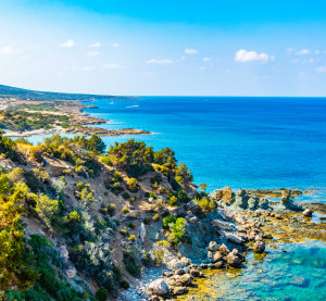 Malerische K&uuml;ste Zyperns mit t&uuml;rkisblauem Meer, felsiger Landschaft und klarem Himmel im Fr&uuml;hling.