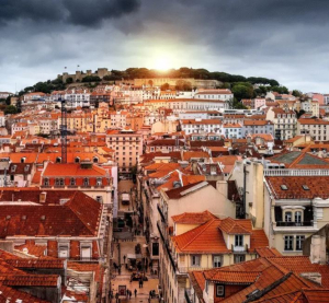Blick &uuml;ber die Altstadt von Lissabon mit roten Ziegeld&auml;chern und dem Castelo de S&atilde;o Jorge im Hintergrund.