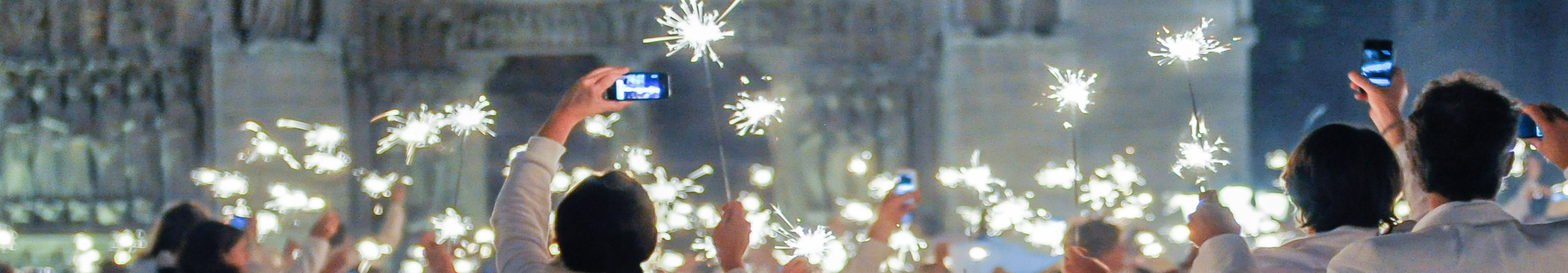 Sternenwerfer und Menschen in wei&szlig;en Klamotten feiern D&icirc;ner en Blanc