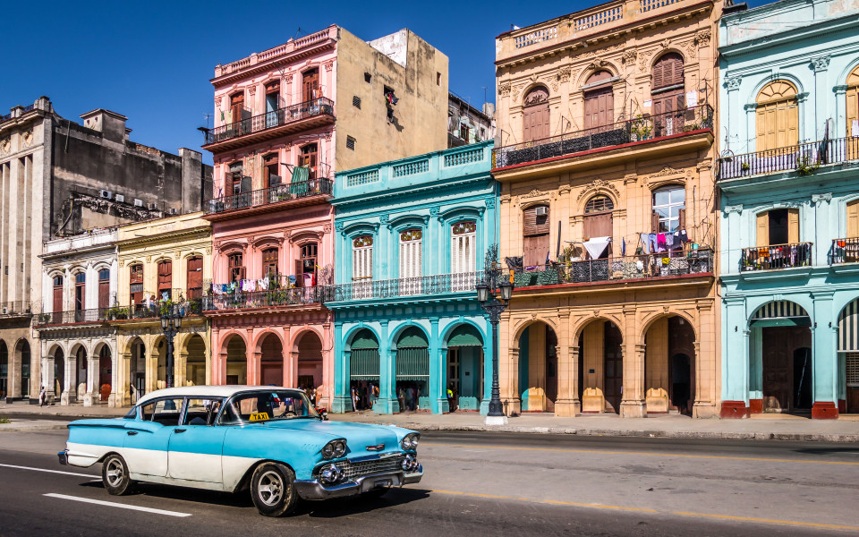Bunte Kolonialgeb&auml;ude und Oldtimer-Taxi in einer Stra&szlig;e von Havanna, Kuba.